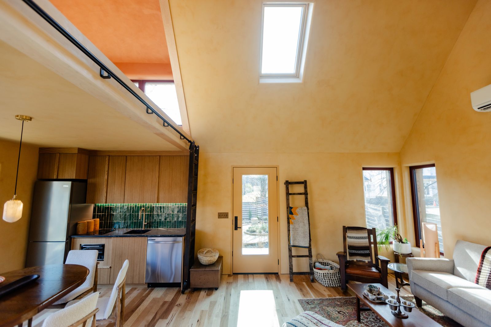 Open studio interior of the passive house, skylight overhead, kitchen along the far wall