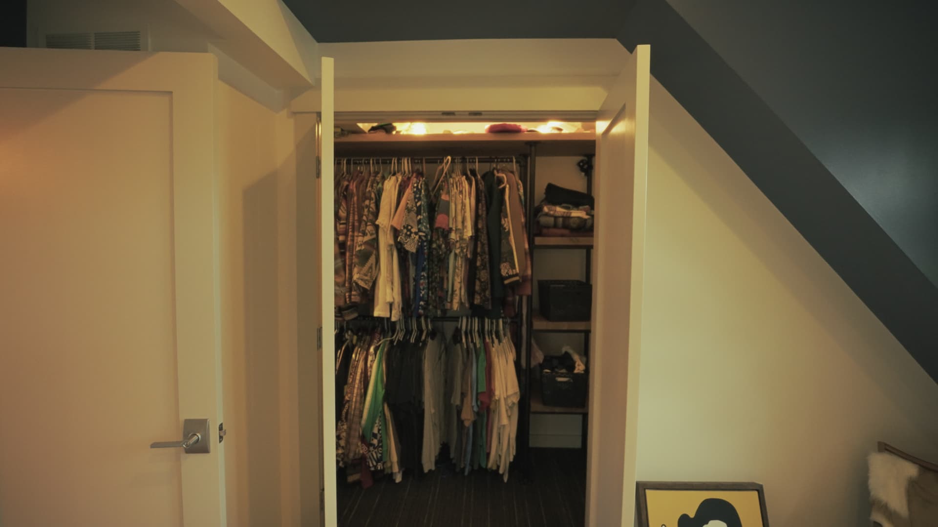 Interior of a walk-in closet with hanging clothes and built-in shelving
