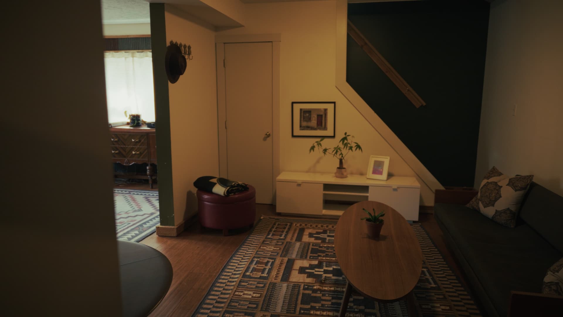 Carriage house living room with a deep green accent wall beside the stair
