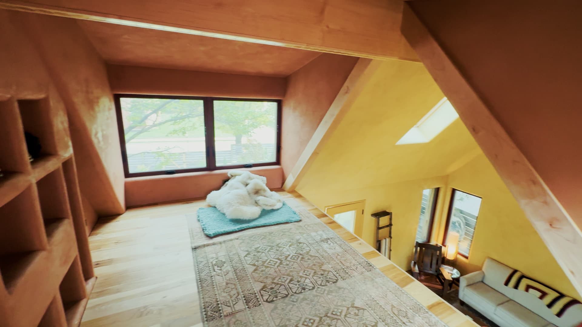 View from the loft of the passive house looking down into the studio, wood floors and plaster walls
